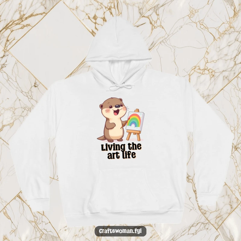 Funny otter hoodie design of a cheerful otter painting a vibrant rainbow on a small canvas with enthusiasm.