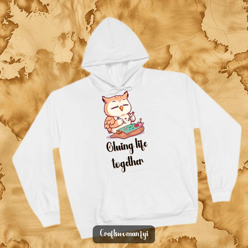 Funny owl hoodie showcasing a content owl meticulously gluing decorative elements onto a craft project, perfect for chilly days.