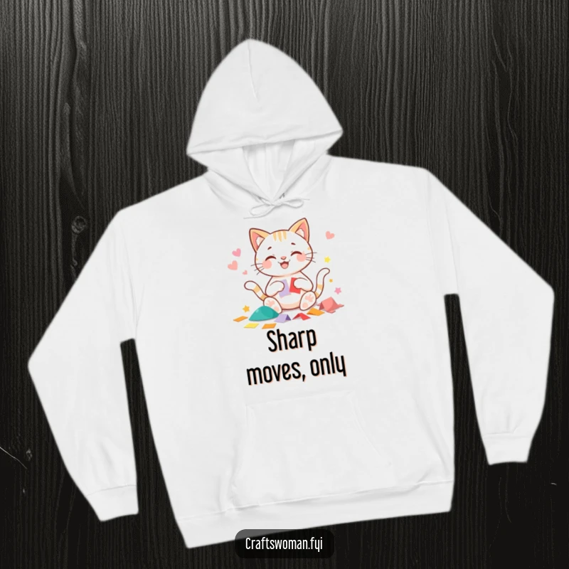 Funny cat hoodie showing a beaming cat character happily cutting precise shapes from colorful paper, perfect for cozy crafting.