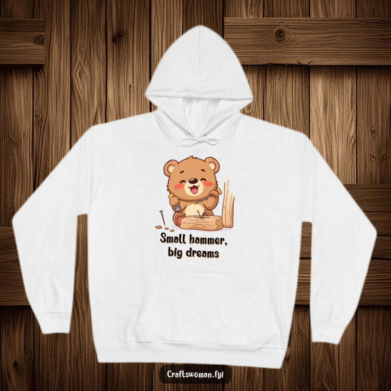 Funny hoodie featuring a gleeful bear cub hammering a tiny nail into wood, perfect for cozy DIY sessions and spreading cheerful humor.