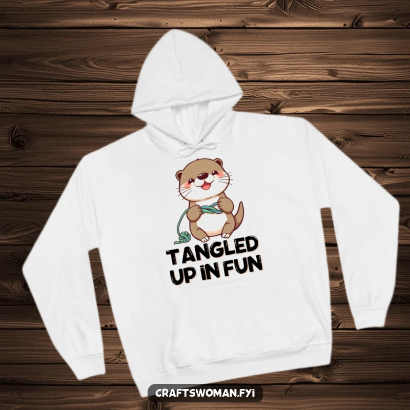 Funny otter hoodie with a smiling character knotting colorful yarn into a playful design, cozy and heartwarming.