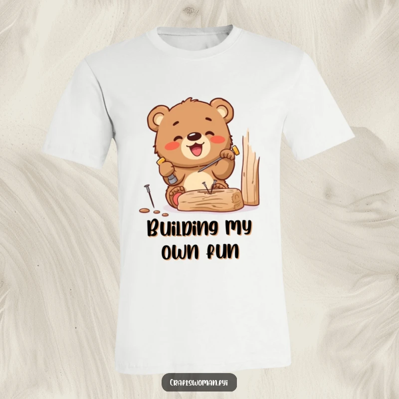 Funny t-shirt depicting a gleeful bear cub happily hammering a small nail into wood, showcasing dedication to DIY projects with a smile.
